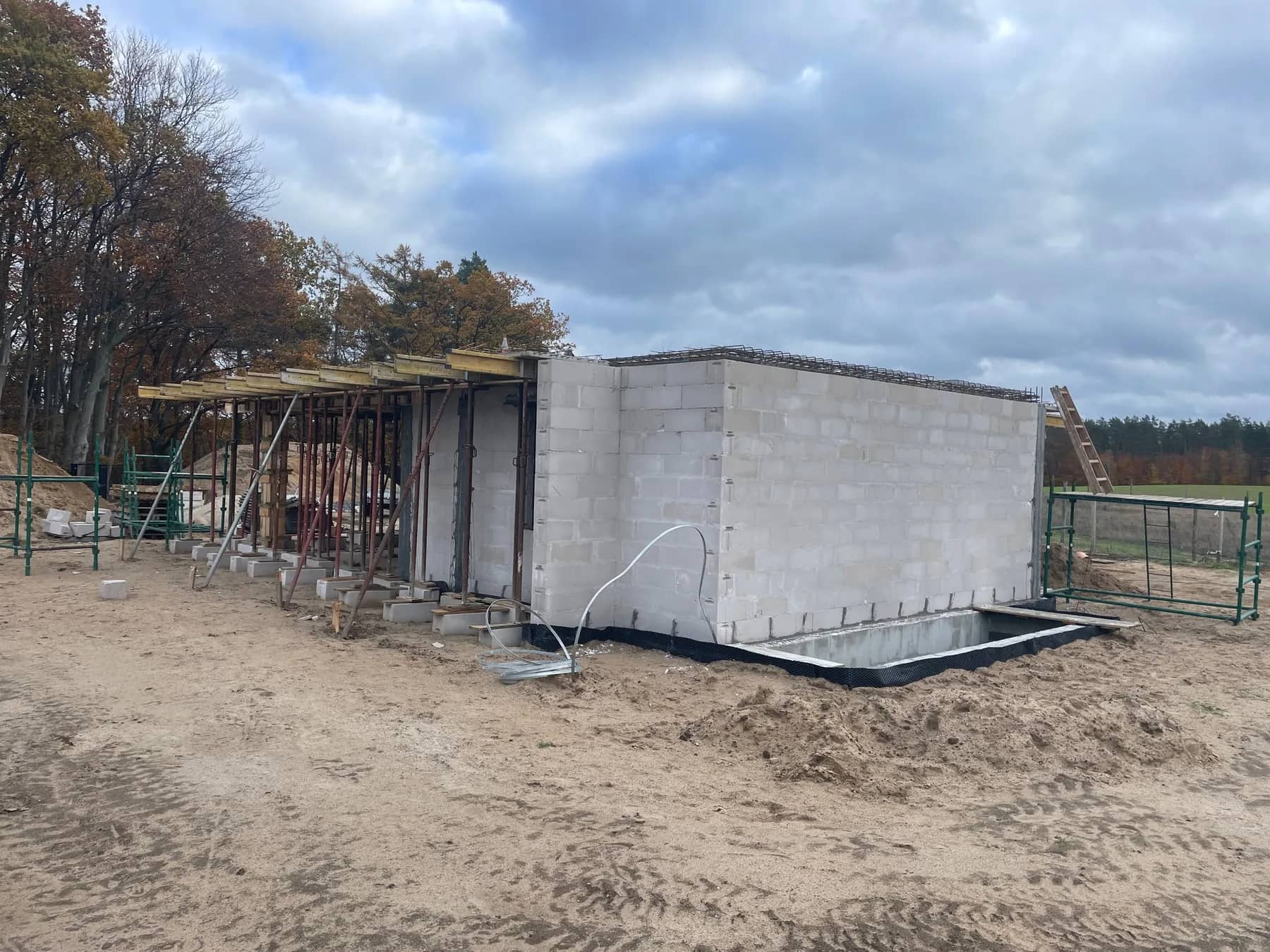 Boczna elewacja domu z oknami na parterze i piętrze
