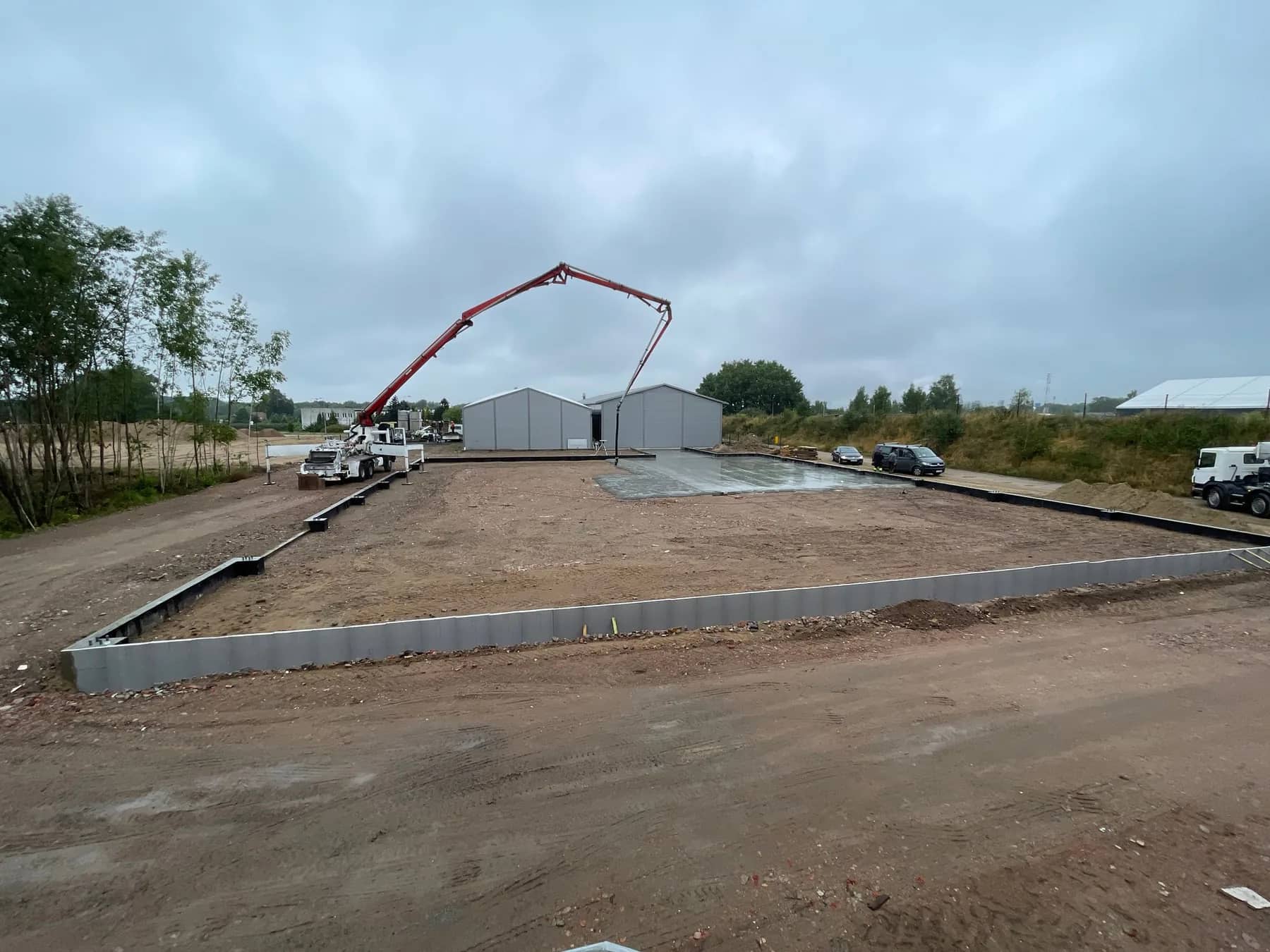 Widok ogólny placu budowy — fundamenty gotowe do montażu konstrukcji stalowej