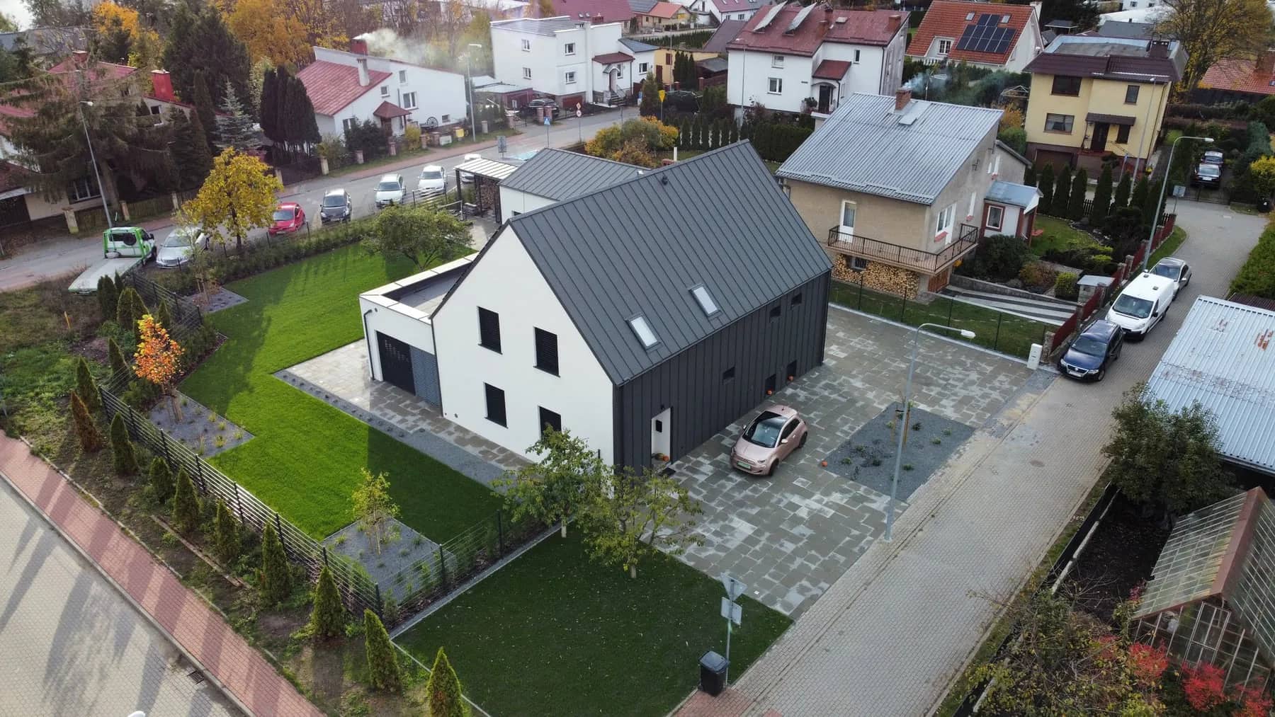 Widok z drona — ukończony dom z zielonym trawnikiem i utwardzonym podjazdem