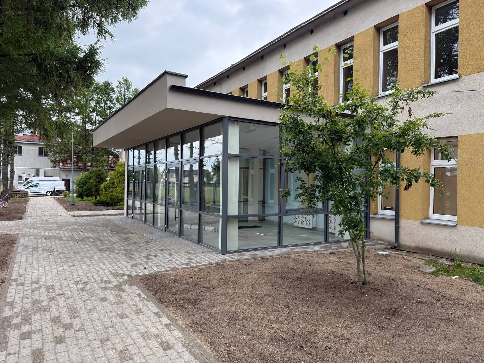 Nowy przeszklony wiatrołap przedszkola w Czaplinku z utwardzonym dojściem do budynku