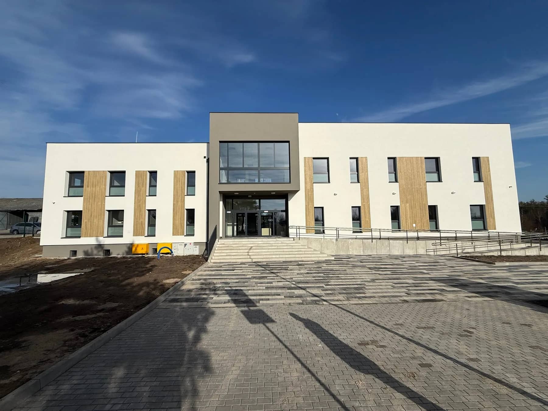 Front budynku zakładu opiekuńczo-pielęgnacyjnego z głównym wejściem i utwardzonym dojściem